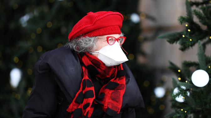 Seorang wanita yang mengenakan masker berjalan melewati sejumlah pohon Natal di Paris, Prancis, 25 November 2020. Warga Prancis akan menikmati lebih banyak kebebasan dalam melakukan berbagai kegiatan di luar ruangan mulai 28 November 2020.(Xinhua/Gao Jing)