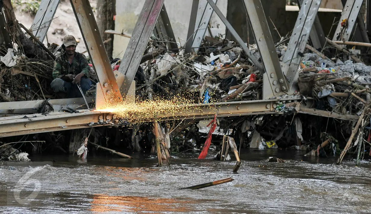 Petugas mengelas besi pondasi jembatan Rawajati untuk mempermudah pembongkaran, Jakarta, Selasa (15/3). Gubernur DKI Basuki Tjahaja Purnama meminta Dinas PU segera membongkar Jembatan tersebut karena menjadi penyebab banjir. (Liputan6.com/Yoppy Renato)