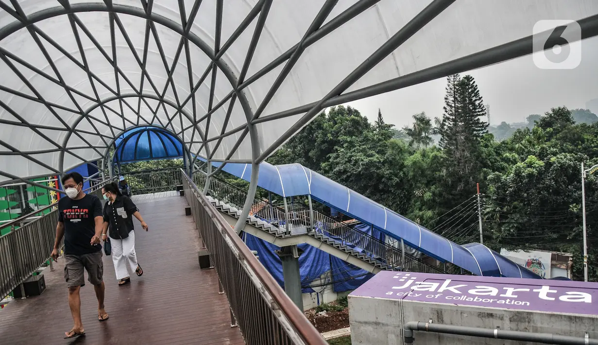 Pejalan kaki saat melintasi jembatan penyeberangan orang (JPO) Flyover Tapal Kuda Lenteng Agung, Jakarta, Minggu (29/8/2021). Diketahui JPO ini telah rampung sejak awal Agustus namun belum tahu kapan akan diresmikan oleh Gubernur DKI Jakarta Anies Baswedan. (merdeka.com/Iqbal S Nugroho)