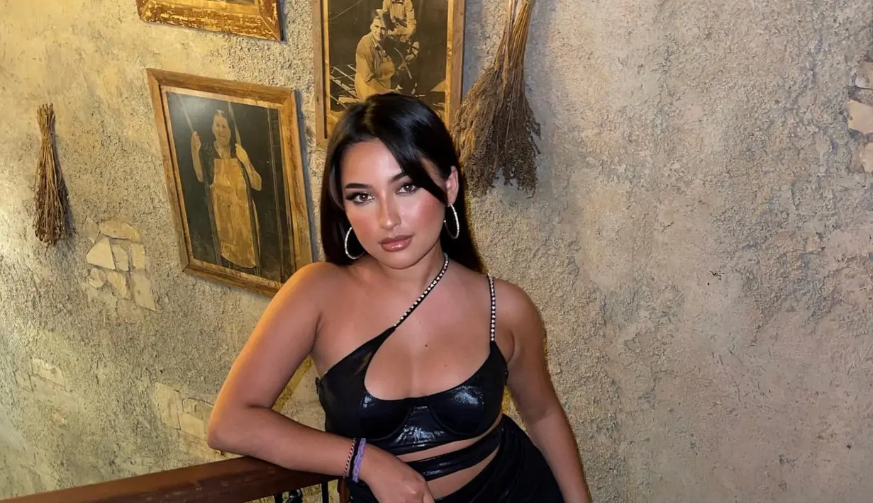 Siluet cut out yang ekstra pada cropped top lateks hitam memberi tampilan seksi dan radiant. [Foto: Instagram @jennifercoppen]