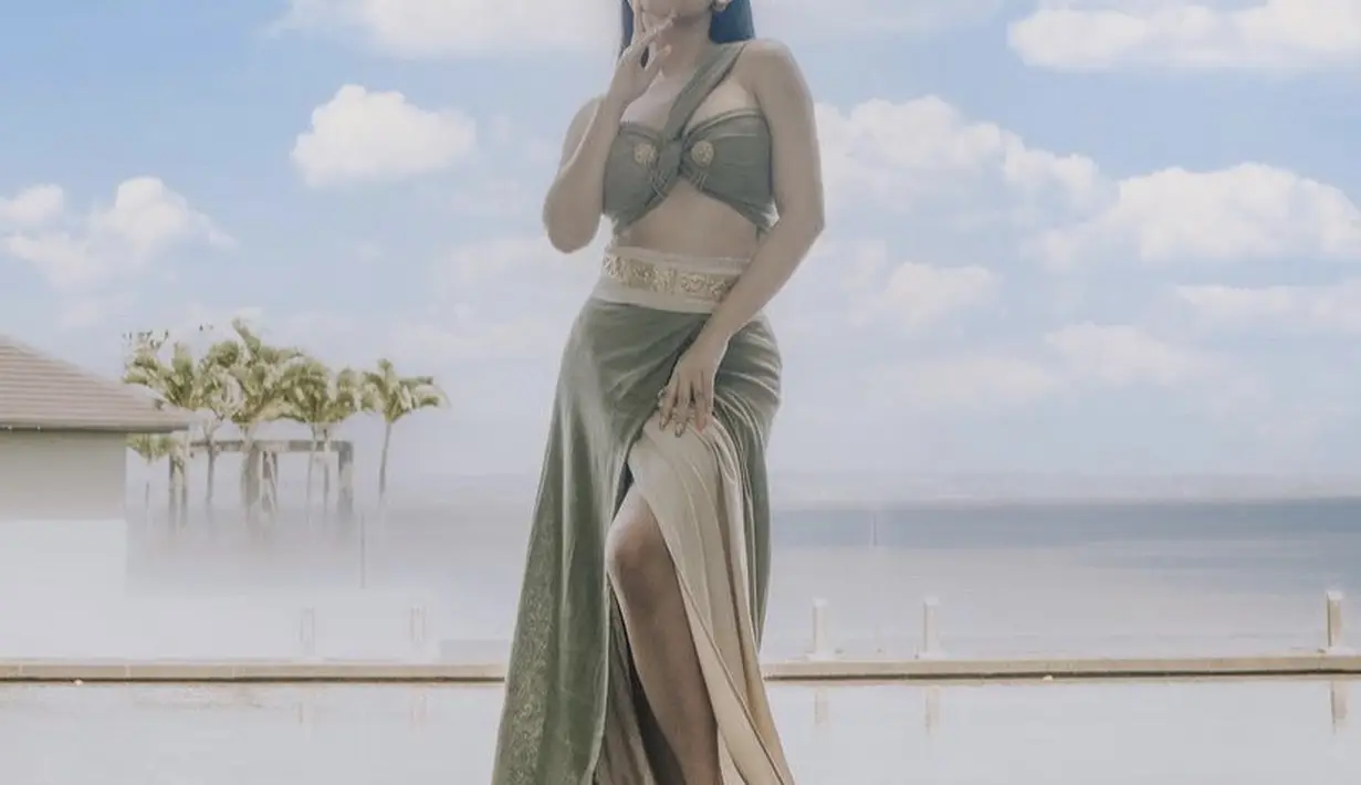 Begitu pun dengan Rachel yang mengenakan atasan model bra dengan sling leher warna hijau dilengkapi bros keemasan serasi dengan anting dan riasan kepalanya. Untuk bawahan, ia mengenan slit skirt hijau nude. (@rachelvennya)