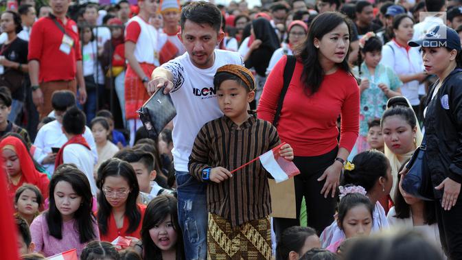 Seorang anak bersiap mengikuti gelaran Harmoni Indonesia 2018 di Kompleks Gelora Bung Karno, Jakarta, Minggu (5/8). Presiden RI, Joko Widodo hadir dalam acara bernyanyi bersama lagu kebangsaan. (Liputan6.com/Helmi Fithriansyah)