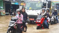 Sejumlah pengendara terjebak banjir akibat luapan kali licin di Jalan Pramuka, Pancoranmas, Kota Depok. (Liputan6.com/Dicky Agung Prihanto)