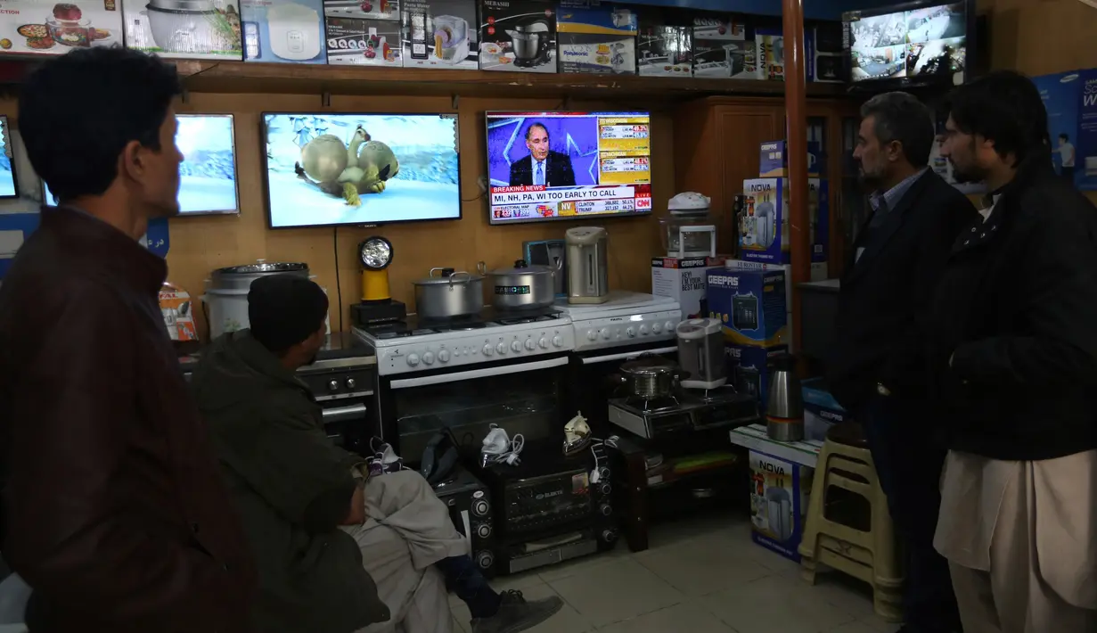 Warga Afghanistan melihat siaran langsung pemilihan presiden AS di sebuah kios perlengkapan memasak di Afghanistan Rabu (9/11). (AP Photo / Rahmat Gul)