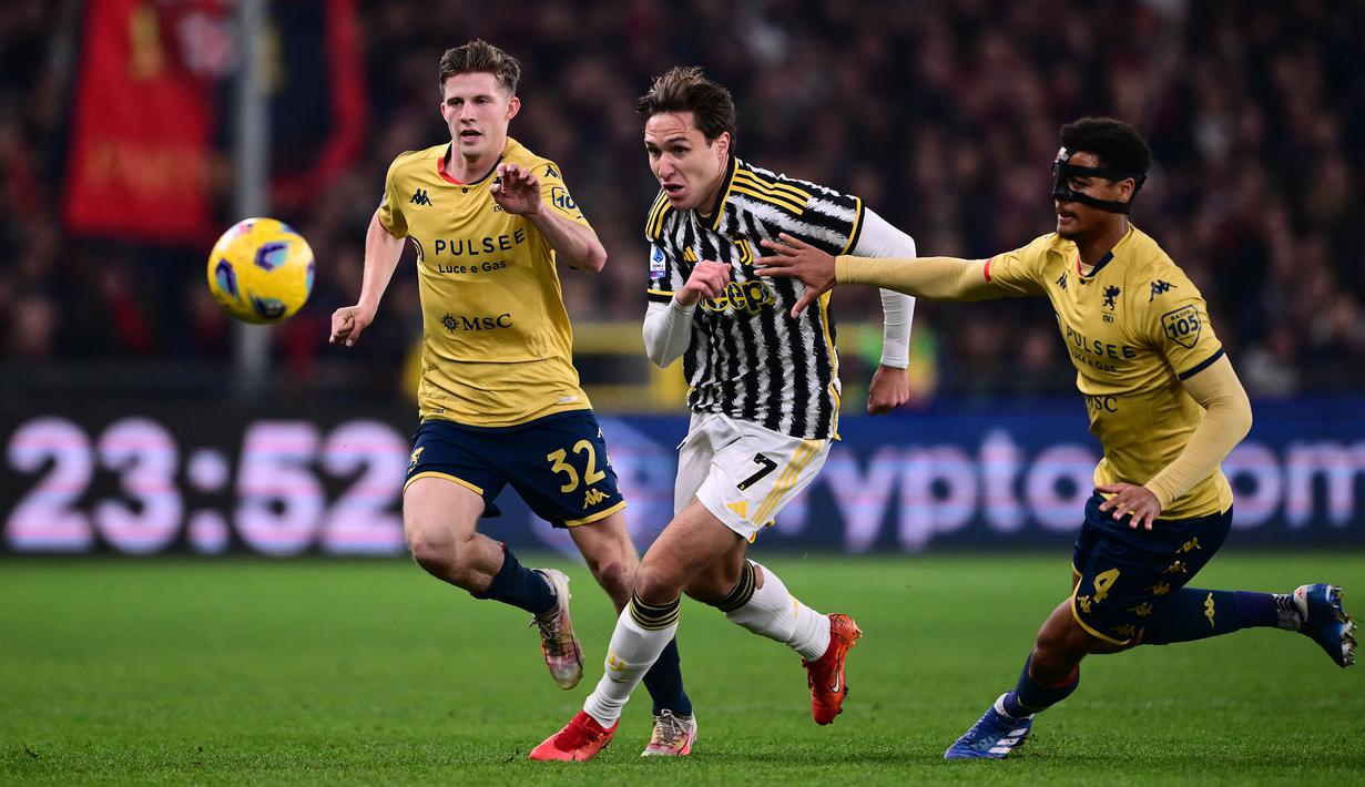 Pemain Genoa, Morten Frendrup (kiri) dan Koni De Winter (kanan) berusaha menghentikan pergerakan dari pemain Juventus, Federico Chiesa (tengah) pada laga lanjutan Liga Italia 2023/2024 di Stadion Luigi Ferraris, Genoa, Italia, Sabtu (16/12/2023) dini hari WIB. Jersey ketiga dari klub berjuluk Il Grifone tersebut didominasi dengan warna emas dengan beberapa corak merah dan biru di bagian leher dan lengannya. (AFP/Marco Bertorello)
