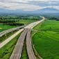 Foto udara pembangunan Gerbang Tol Ujung Jaya Utama bagian dari Tol Cileunyi-Sumedang-Dawuan (Cisumdawu) seksi enam di Kabupaten Majalengka, Jawa Barat, Rabu (28/12/2022). Kementerian Koordinator Bidang Perekonomian melalui KPPIP meninjau progress dan optimalisasi untuk akses jalan tol menuju Bandara Kertajati dan solusi antisipasi kemacetan jalan nasional Bandung ke Majalengka serta target fungsional secara keseluruhan di kwartal satu 2023 dalam mendukung arus mudik lebaran. (Liputan6.com/Angga Yuniar)