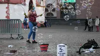 Seorang seniman jalanan yang mengenakan masker membuat gelembung sabun di sebuah alun-alun di Frankfurt, Jerman, 2 November 2020. Total infeksi COVID-19 di Jerman kini bertambah menjadi 545.027 kasus. (Xinhua/Lu Yang)