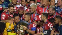 Kapten tim Flamengo Diego (kiri) mencium trofi disaksikan rekan satu timnya usai menjuarai Liga Brasil di Sao Paulo, Kamis (25/2/2021). (Foto: AFP/Nelson Almeida)