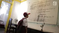 Siswa SDN Menteng Atas 05 Pagi mengamati replika naskah Proklamasi di Museum Perumusan Naskah Proklamasi di Menteng, Jakarta, Selasa (20/8/2019). Kunjungan tersebut merupakan bentuk pendidikan sekaligus pengenalan sejarah perjuangan Bangsa Indonesia sejak usia dini. (Liputan6.com/Faizal Fanani)