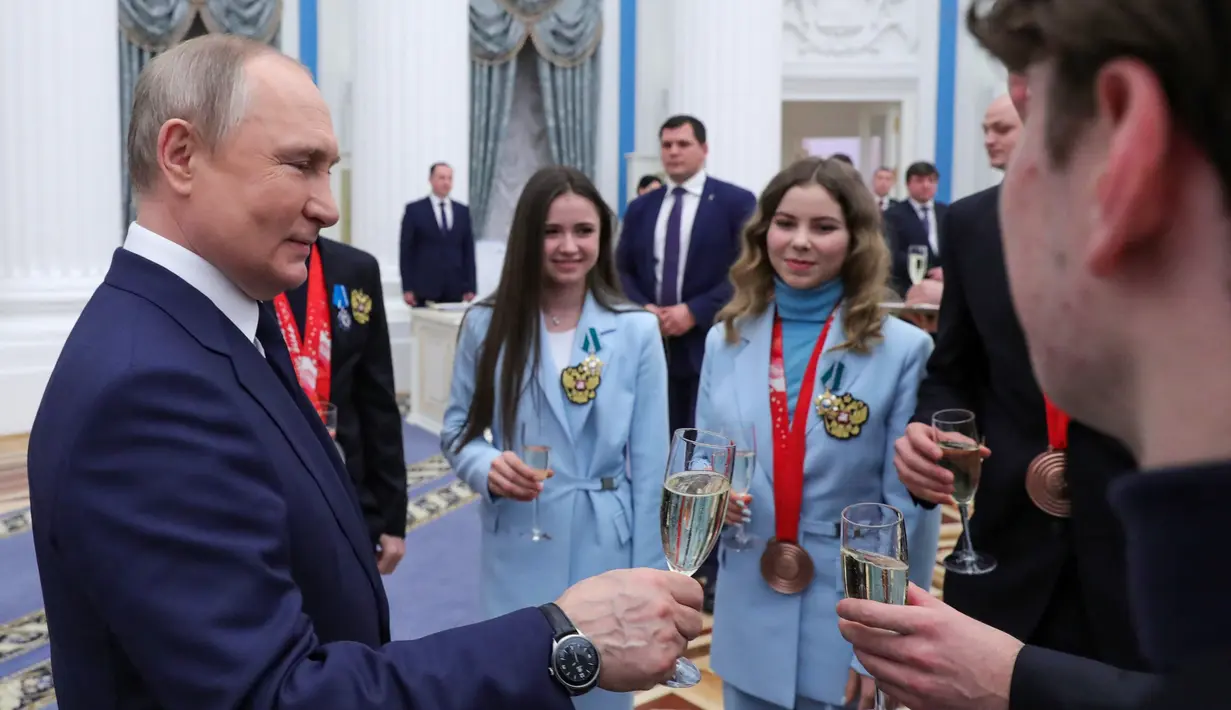 <p>Presiden Rusia Vladimir Putin bersulang dengan atlet Rusia setelah upacara penghargaan untuk pemenang medali Olimpiade Musim Dingin Beijing 2022 di Kremlin di Moskow (26/4/2022). (Mikhail KLIMENTYEV/SPUTNIK/AFP)</p>