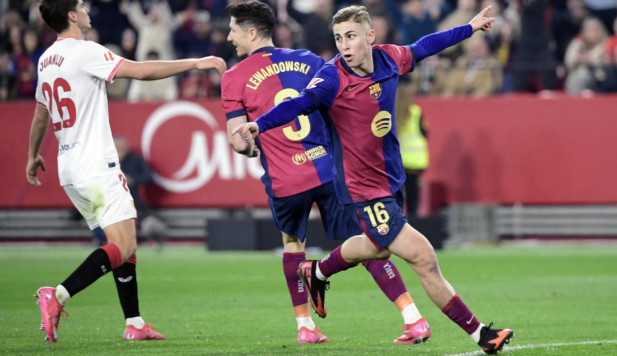 Pemain Barcelona, Fermin Lopez melakukan selebrasi setelah mencetak gol kedua timnya ke gawang Sevilla dalam laga lanjutan Liga Spanyol 2024/2025 di Ramon Sanchez Pizjuan Stadium, Sevilla, Spanyol, Senin (10/02/2025) dini hari WIB. (AFP/Cristina Quicler)