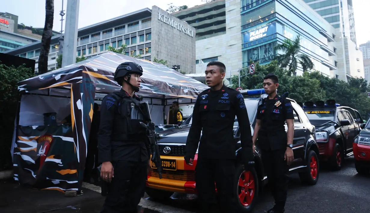 Personel Brimob melakukan koordinasi pengamanan jelang malam pergantian tahun di kawasan Bundaran Hotel Indonesia, Minggu (31/12). TNI dan Polri dikerahkan untuk mengamankan malam tahun baru 2018 di Jakarta. (Liputan6.com/Helmi Fithriansyah)