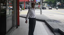 Seorang lelaki tua mengenakan masker saat kabut menyelimuti Kuala Lumpur, Malaysia (10/9/2019). Ratusan sekolah di seluruh Asia Tenggara ditutup karena kabut asap beracun akibat kebakaran hutan. (AFP Photo/Mohd Rasfan)