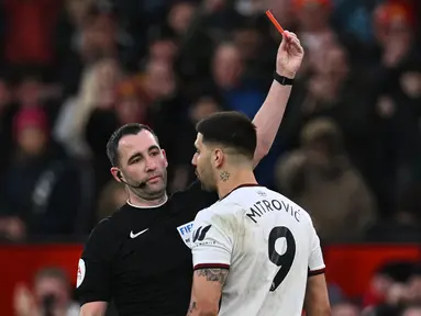 Wasit Chris Kavanagh (kiri) memberikan kartu merah kepada Aleksandar Mitrovic yang melakukan protes berlebihan dalam babak perempat final Piala FA 2022/2023 melawan Manchester United di Old Trafford, Minggu (19/3/2023) malam WIB. (AFP/Paul Ellis)