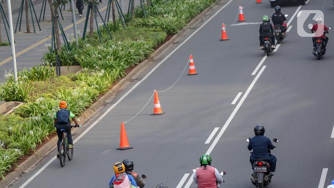 Warga bersepeda setelah jam kerja di jalur khusus sepeda kawasan Jalan Sudirman, Jakarta, Selasa (14/7/2020). Jalur sepeda bernama pop-up bike lane yang berada di sepanjang Jalan Jenderal Sudirman dan MH Thamrin berjarak sekitar 14 Km. (Liputan6.com/Fery Pradolo)