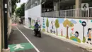 Pengendara sepeda motor melintas di depan mural dan akses khusus pejalan kaki di Jalan Darul Maarif, Jakarta Selatan, Rabu (11/3/2020). PT MRT Jakarta berkolaborasi dengan ITDP menata jalan-jalan sekitar stasiun untuk meningkatkan aksesibilitas warga sekitar. (Liputan6.com/Immanuel Antonius)