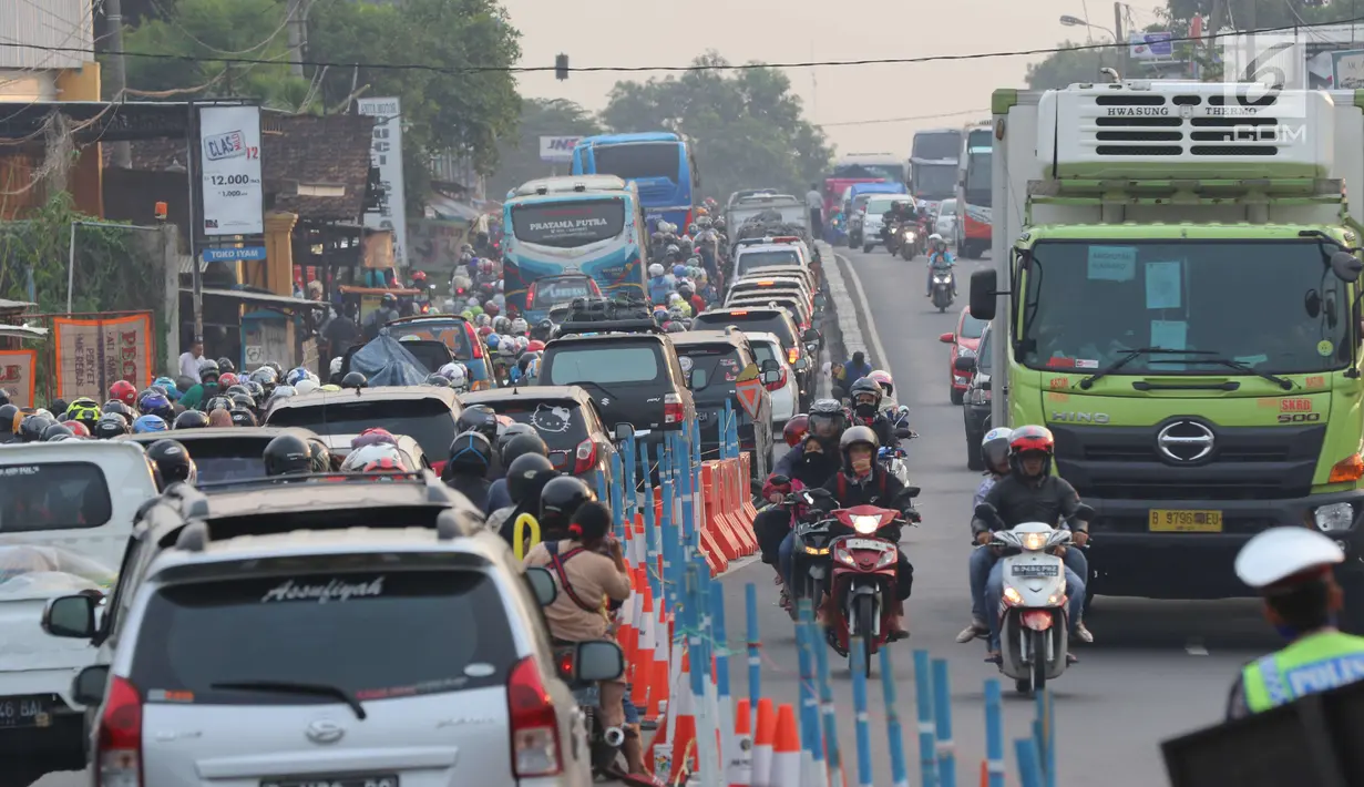 Arus lalu lintas dari Jalur Pantura Cikampek mengarah Jakarta terlihat macet di jalan Jendral Sudirman,Cikampek,  Jawa Barat, Sabtu (7/1). (Liputan6.com/Helmi Afandi)