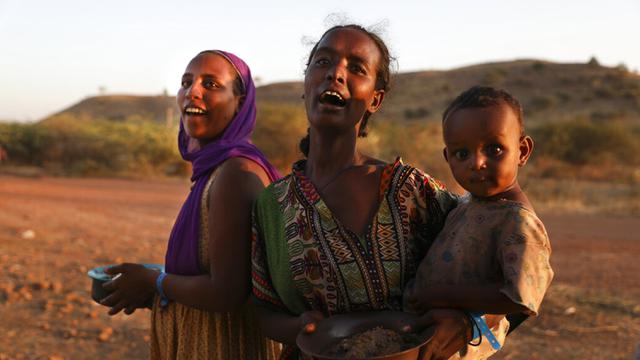 <span>Pengungsi Ethiopia menggendong seorang anak di wilayah Qadarif, Sudan, Rabu (18/11/2020). Pertempuran yang kian meluas di perbatasan Ethiopia dan Sudan mengancam wilayah Tanduk Afrika. (AP Photo/Marwan Ali)</span>