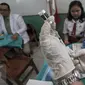 Dokter bersiap memberikan suntikan imunisasi di SDN 11 Pagi, Lubang Buaya, Jakarta, Selasa (4/10). Kegiatan ini untuk mewujudkan Indonesia bebas dari kanker serviks. (Liputan6.com/Faizal Fanani)