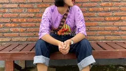 Seperti gaya OOTD-nya ini. Pakai kaus ungu dan celana jeans biru dongker, penampilannya kian modis dengan kets putih serta binnie.(Liputan6.com/IG/@fuji_an)