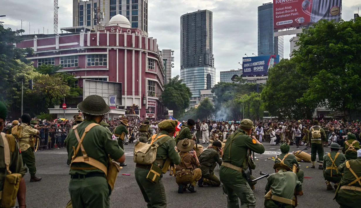 Anggota Komunitas Roode Brug Soerabaia dan Reenactor Indonesia berpartisipasi dalam reka ulang Pertempuran Surabaya, di Surabaya pada Minggu 2 November 2025. Pertunjukan dibuka dengan pembacaan puisi, disusul adegan kemarahan arek-arek Suroboyo yang menyobek selebaran pasukan Sekutu. (Juni KRISWANTO/AFP)
