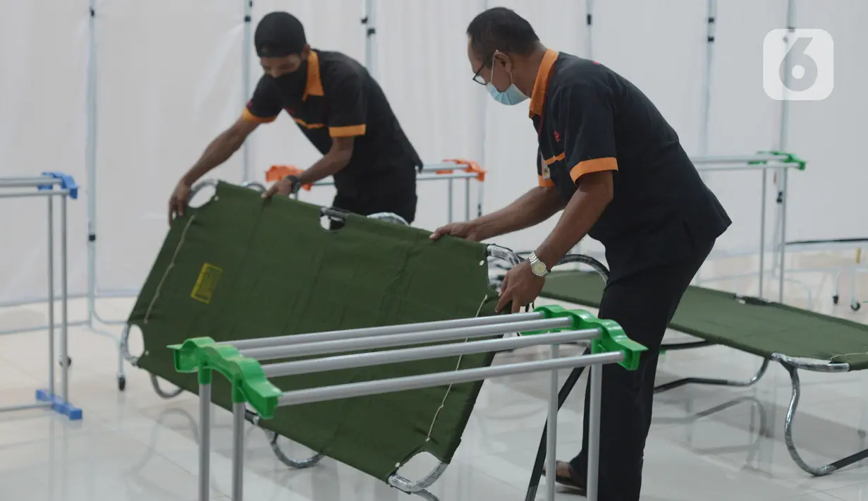 Petugas memasang velbed di ruangan yang dijadikan tempat isolasi pasien COVID-19 di Gelanggang olahraga (GOR) Matraman, Jakarta Timur, Rabu (14/7/2021). Sebanyak 30 tempat tidur disiapkan bagi pasien dengan status orang tanpa gejala (OTG) hingga gejala ringan. (merdeka.com/Imam Buhori)