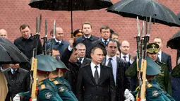 Presiden Rusia, Vladimir Putin memeriksa pasukan kehormatan sebelum meletakkan karangan bunga ke makam prajurit tak dikenal pada peringatan invasi Nazi Jerman ke 76 tahun di Moskow, Kamis (22/6). (Alexei Druzhinin/Sputnik, Kremlin Pool Photo via AP)