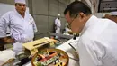 Seorang juri memeriksa sushi buatan peserta dari Norwegia pada World Sushi Cup Japan 2016 di Tokyo, Kamis (18/8). Kejuaraan tahunan ini digelar selama dua hari dan didukung oleh pemerintahan Jepang. (Toru Yamanaka / AFP)
