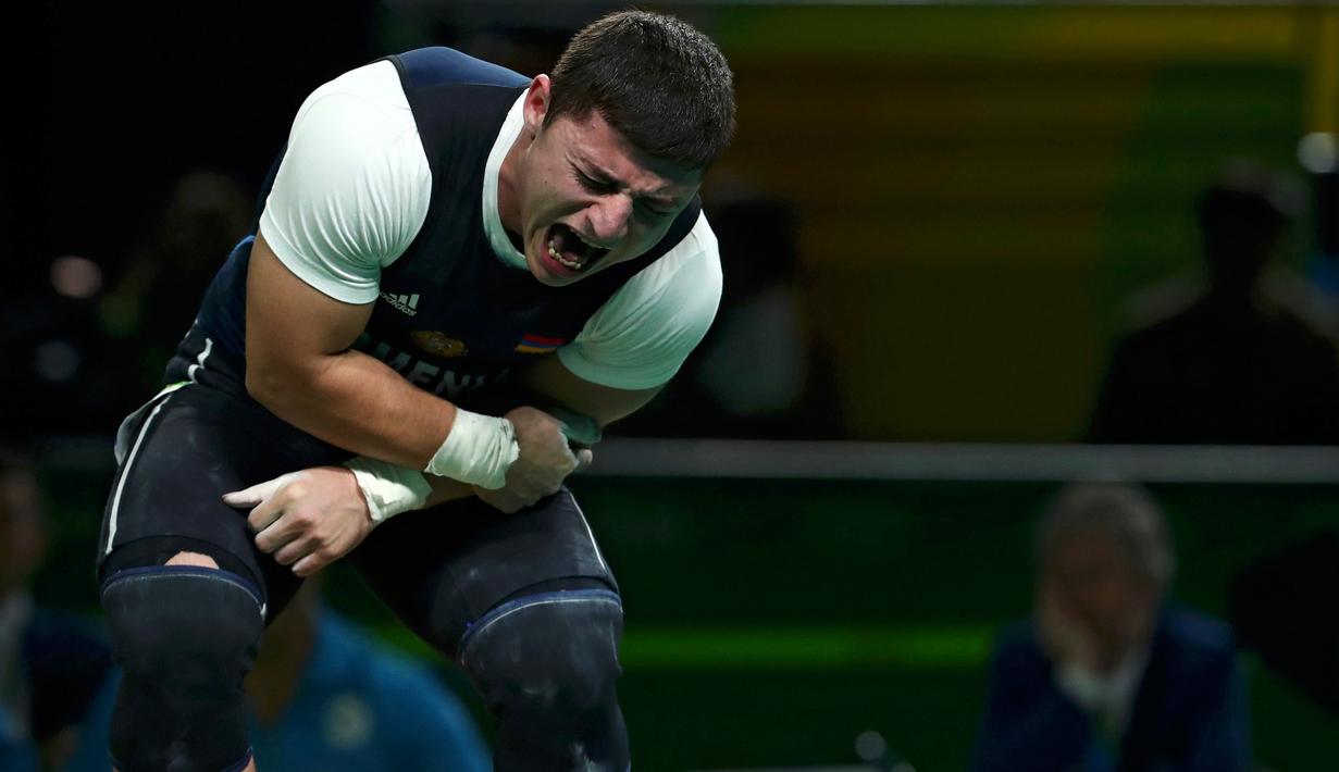 Atlet angkat besi Armenia, Andranik Karapetyan berteriak kesakitan usai mengalami cedera horor ketika tampil pada Olimpiade 2016 di Rio de Janeiro, Rabu (10/8). Siku Karapetyan patah saat hendak mengangkat beban 195 kilogram (REUTERS/Yves Herman)