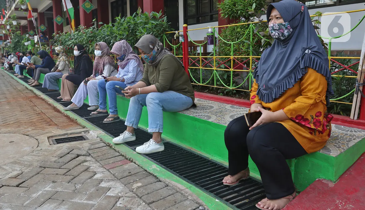 Orang tua murid menunggu waktu pulang sekolah di SDN 05 Kalisari, Jakarta, Senin (30/8/2021). Pemprov DKI Jakarta menggelar pembelajaran tatap muka di tengah pandemi covid-19 mulai 30 Agustus 2021 secara terbatas dengan kapasitas 50 persen pada setiap satuan pendidikan (Liputan6.com/Herman Zakharia)