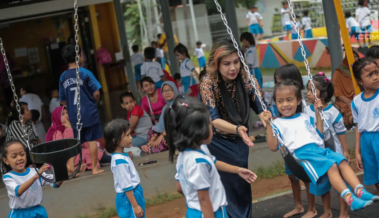 Pendiri Yayasan Pansophia Nusantara, Millie Lukito bermain bersama anak-anak Pendidikan anak usia dini (PAUD) Cahaya Permata Indonesia (CPI) di Rusunawa Marunda, Jakarta Utara, Jumat (30/11). (Liputan6.com/Faizal Fanani)