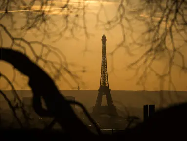 Pemandangan Menara Eiffel yang diselimuti kabut polusi, Paris, Prancis (3/12). Kondisi berkabut ini terjadi karena dinginnya udara malam dan hangatnya suhu siang hari, sehingga polusi kendaraan terperangkap dan sulit hilang. (AFP/Lionel Bonaventure)