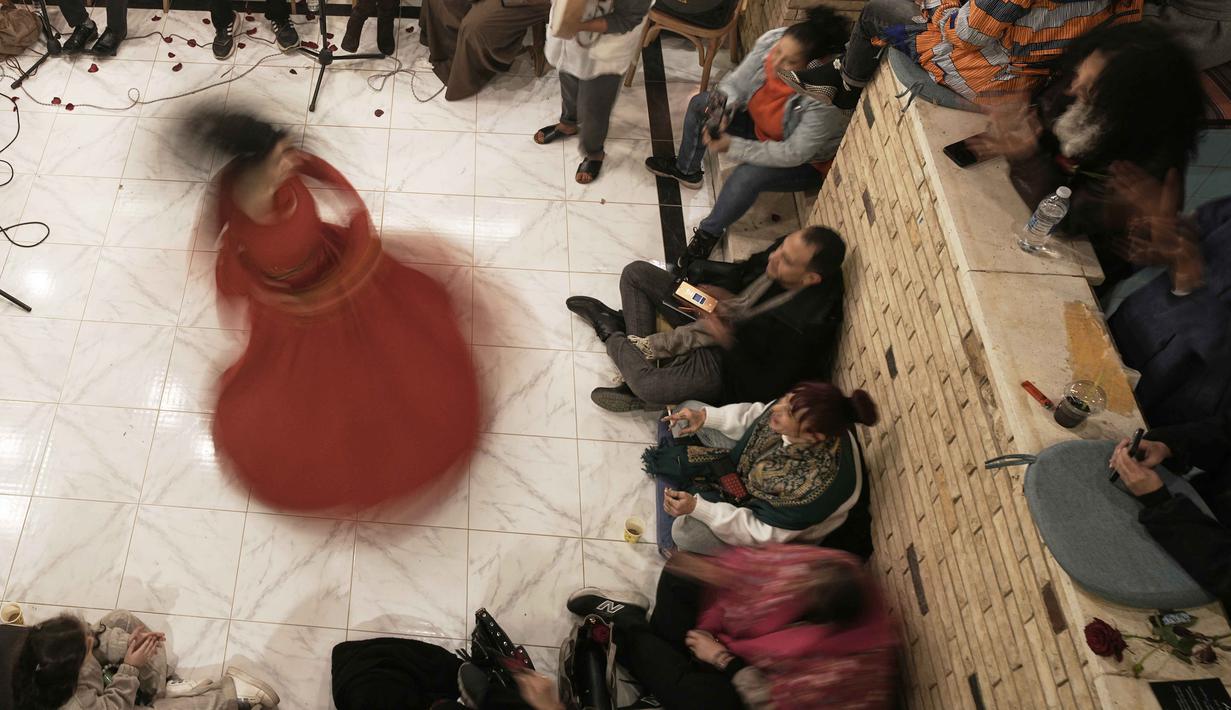Terinspirasi dari Jalaluddin Rumi, tarian ini simbol alam semesta yang mengorbit Tuhan, di mana tangan kanan menengadah menerima hidayah, dan tangan kiri menghadap ke bawah membagikan cinta kasih. Tampak dalam foto, penari darwis wanita, Afnan Shaher, berputar saat disambut oleh para penggemarnya dalam pertunjukan keagamaan untuk menandai bulan suci Ramadan di Arab Digital Expression Foundation (ADEF), di Kairo, Mesir, Jumat 27 Februari 2026. (AP Photo/Amr Nabil)
