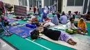 Pemkab juga membangun dapur umum, pos kesehatan dan distribusi logistik sejak dua hari terakhir. Tampak dalam foto, warga desa terdampak banjir beristirahat di tempat pengungsian setelah banjir bandang melanda Meureudu, Kabupaten Pidie Jaya, Provinsi Aceh, pada 29 November 2025. (CHAIDEER MAHYUDDIN/AFP)