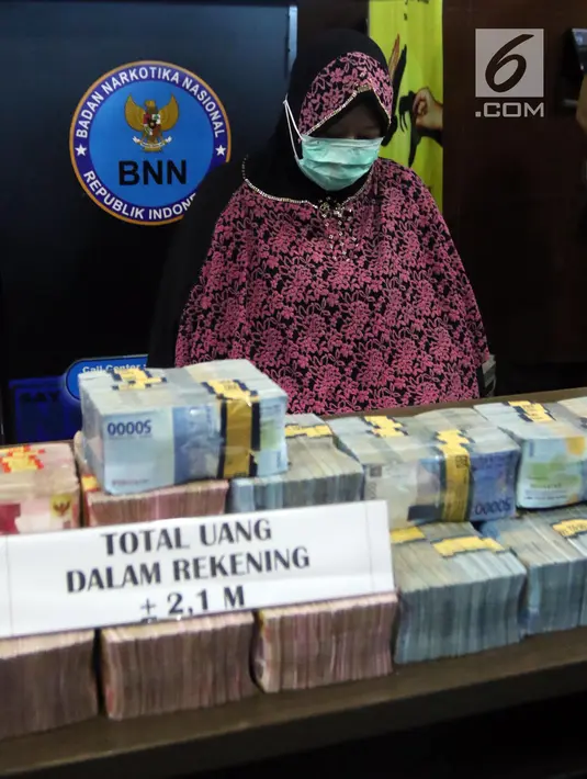 Pemilik rekening PT Surya Subur Jaya yang diduga terlibat dalam kejahatan TPPU, IN ditunjukkan beserta barang bukti uang di Kantor BNN, Jakarta, Selasa (17/7). IN diduga menerima dana dari bandar narkoba sebesar Rp 3,9 Miliar. (Liputan6.com/Arya Manggala)