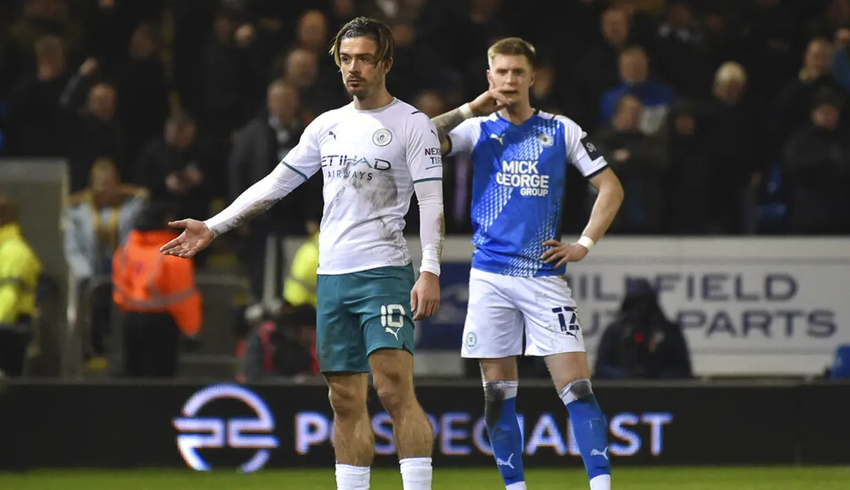 Pemain Manchester City Jack Grealish (kiri) memberi isyarat saat melawan Peterborough United pada pertandingan sepak bola putaran kelima Piala FA di Stadion Weston Homes, Peterborough, Inggris, 1 Maret 2022. Manchester City menang 2-0. (AP Photo/Rui Vieira)