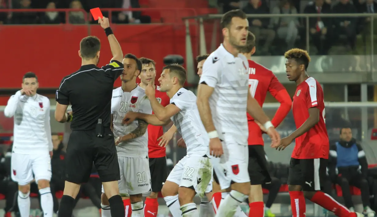 Wasit Ivan Kruzliak asal Slowakia mengeluarkan kartu merah untuk gelandang Albania, Ergys Kace, pada laga uji coba di Stadion Ernst Happel, Wina, Minggu (27/3/2016) dini hari WIB. (Bola.com/Reza Khomaini)