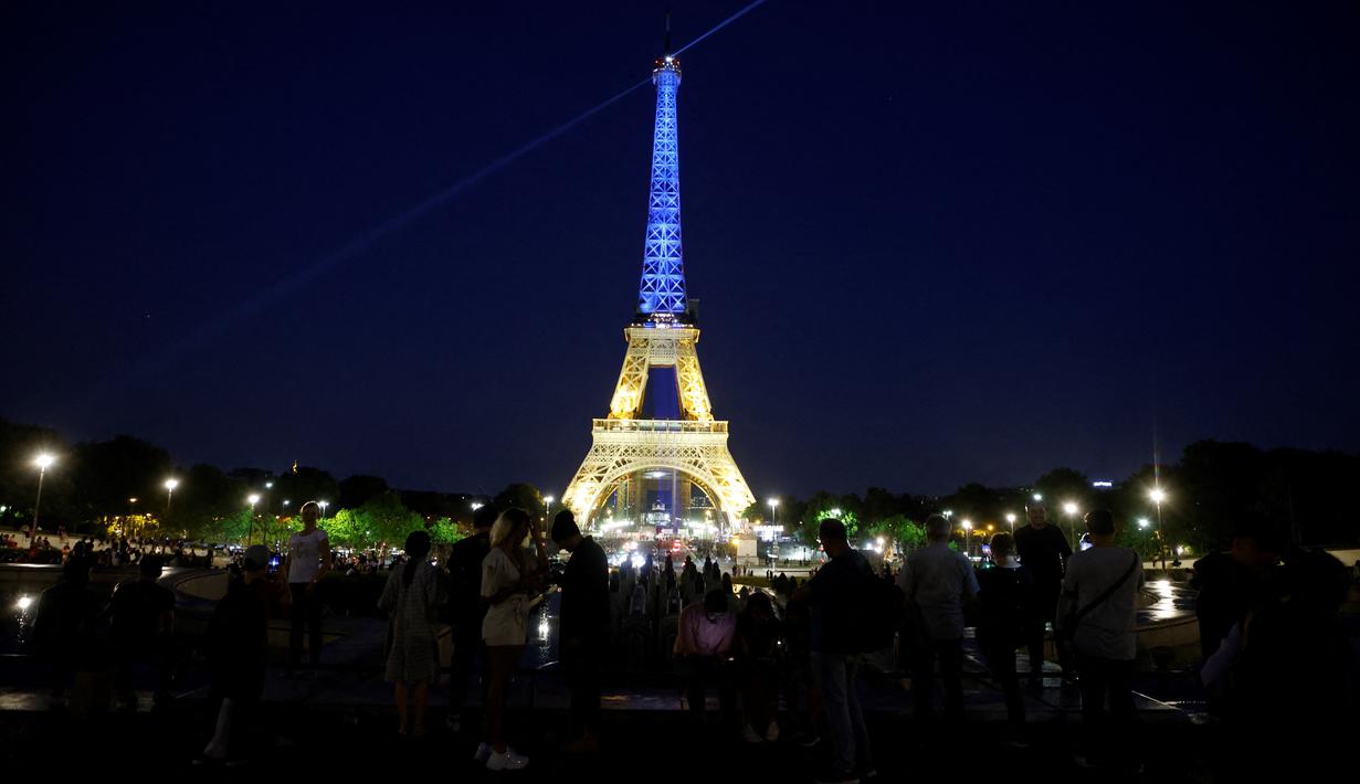 <p>Sebuah foto menunjukkan Menara Eiffel di Paris diterangi dengan warna bendera nasional Ukraina, pada 9 Mei 2022. Memperingati Hari Eropa, Menara Eiffel memproyeksikan bendera Ukraina sebagai solidaritas untuk rakyat Ukraina di tengah invasi Rusia. (Ludovic MARIN / AFP)</p>