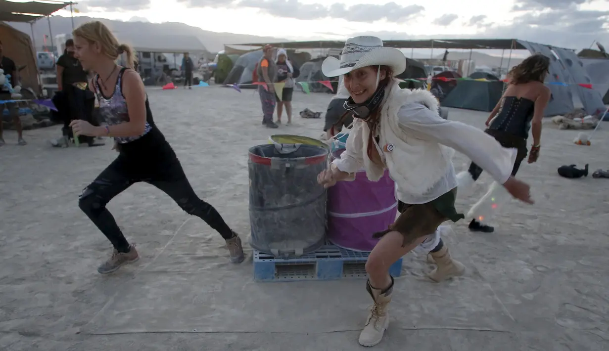 Pengunjung berlari saat mengikuti Carnival of Death dalam festival Burning Man 2015 di Gurun Black Rock, Nevada, (3/9/2015). Partisipan dari seluruh dunia hadiri festival seni unik ini selama sepekan. (REUTERS/Jim Urquhart)