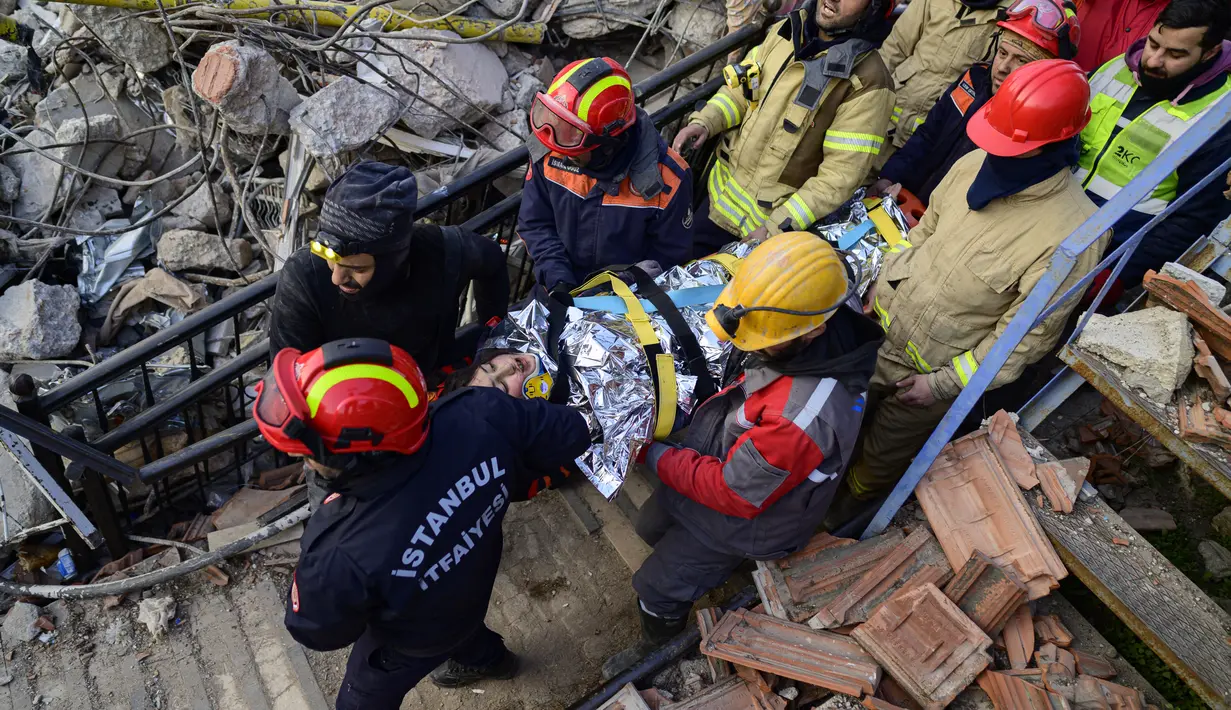 Tim penyelamat mengevakuasi seorang gadis Suriah berusia 12 tahun, Cudi, dari puing-puing bangunan yang hancur di Hatay, Turki, setelah gempa berkekuatan 7,8 melanda tenggara negara itu, Minggu (12/2/2023). Hatay, yang berbatasan dengan barat laut Suriah adalah provinsi terparah di Turki yang terkena gempa dahsyat.  (Photo by Yasin AKGUL / AFP)