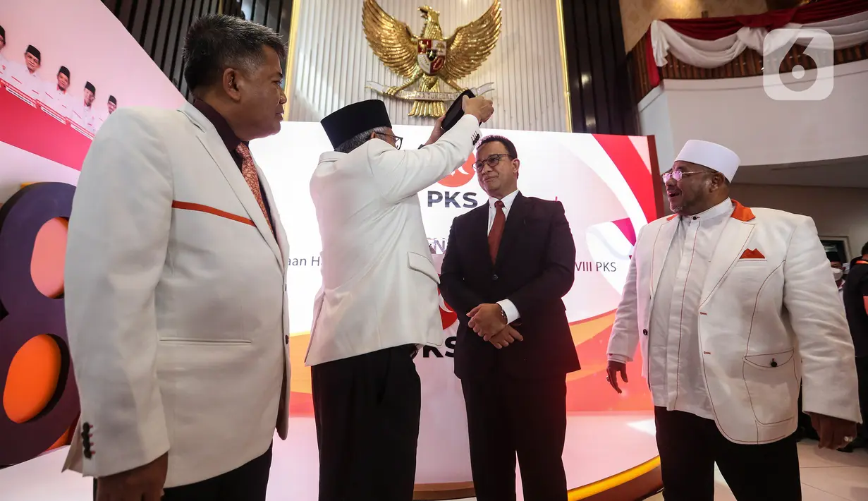 Presiden PKS Ahmad Syaikhu menyematkan peci kepada mantan Gubernur DKI Jakarta Anies Rasyid Baswedan (kedua kanan) sebagai tanda dukungan sebagai bakal calon presiden 2024-2029 usai pembacaan hasil keputusan Musyawarah Majelis Syuro VIII PKS di Jakarta, Kamis (23/2/2023). PKS secara resmi mendukung Anies Baswedan sebagai bakal calon presiden tahun 2024-2029. (Liputan6.com/Johan Tallo)
