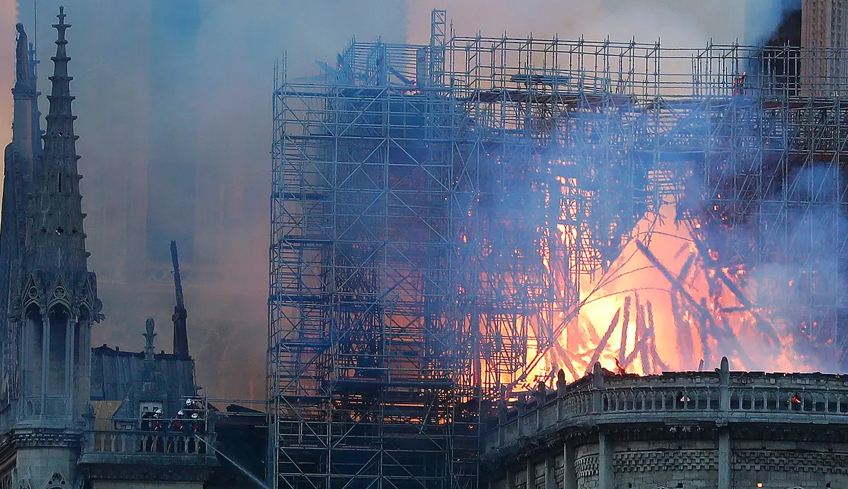 Petugas pemadam kebakaran berusaha memadamkan api dari Gereja Katedral Notre-Dame di kota Paris, Prancis, pada Senin (15/4). Tidak ada laporan korban jiwa dalam kebakaran yang terjadi menjelang perayaan Paskah yang jatuh pada 21 April mendatang. (AP Photo/Thibault Camus)
