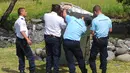 Polisi memeriksa potongan mirip badan pesawat yang diduga milik MH370 di pantai Saint - Andre, Perancis, Rabu (29/30/2015).  Diduga puing tersebut adalah potongan badan pesawat dari Malaysia Airlines MH370 yang hilang tahun lalu. (REUTERS/Prisca Bigot)