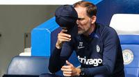 Pelatih Chelsea, Thomas Tuchel menutup wajahnya dari semburan sinar matahari dengan topinya saat memantau jalannya pertandingan pekan keenam Liga Inggris 2022/2023 antara Chelsea melawan West Ham United. (AFP/Adrian Dennis)