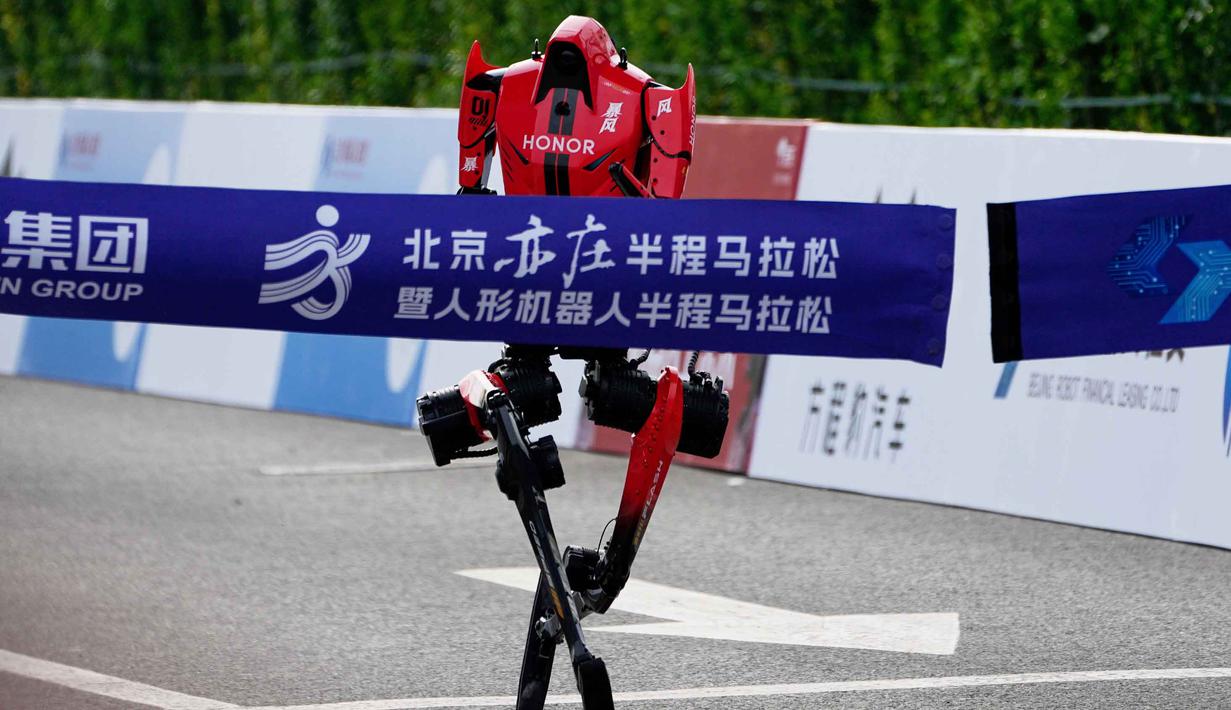 Namun, pada lomba tahun ini, peningkatan performa terlihat jelas dengan sejumlah robot mampu berlari stabil dan bersaing ketat. Tampak dalam foto, sebuah robot melintasi garis finis dalam ajang Beijing E-Town Half Marathon dan Humanoid Robot Half-Marathon yang diadakan di pinggiran Beijing, Minggu 19 April 2026. (AP Photo/Andy Wong)