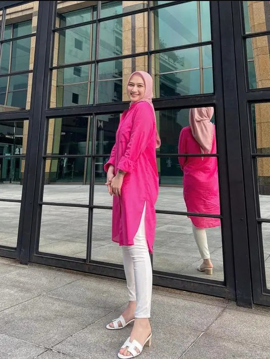 Kombinasi kemeja tunik warna pink fuschia dengan hijab segi empat baby pink cocok dipadukan dengan skinny jeans dan heels warna putih.  (Instagram/melodylaksani92).