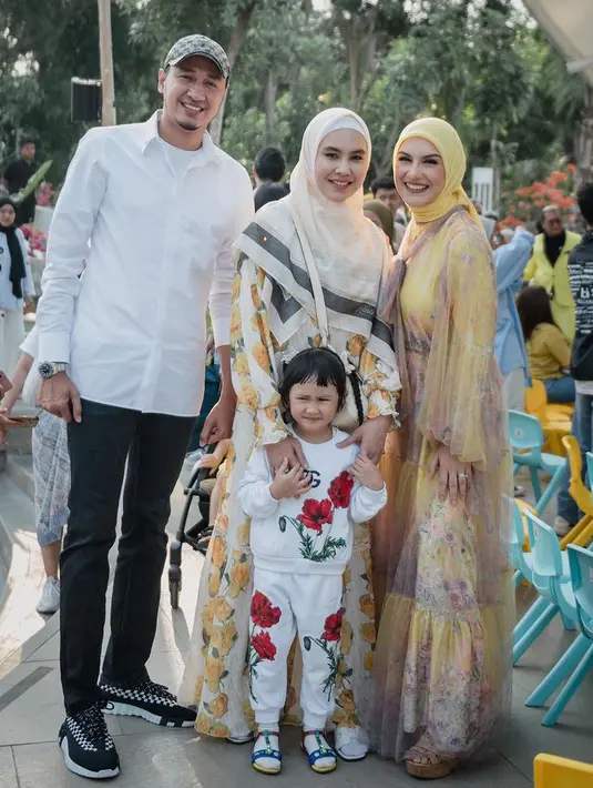Kartika Putri tampil dengan dress panjang warna putih dengan motif bunga kuning serasi dengan kerudung putihnya.  [@_irishbella_]