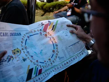 Seorang pria membaca Surat kabar Malaysia, Metro Ahad, saat perhelatan  SEA Games 2017 di Kuala Lumpur, Minggu (20/8). Koran tersebutmemasang bendera Indonesia terbalik, yaitu putih di bagian atas dan bawah berwarna merah. (Liputan6.com/Faizal Fanani)