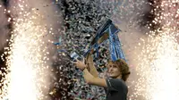 Petenis Jerman, Alexander Zverev memegang trofi setelah mengalahkan Novak Djokovic pada laga puncak ATP Finals 2018 di O2 Arena, London, Senin (19/11). Zverev mengalahkan petenis nomor satu dunia dalam dua set langsung 6-4, 6-3. (AP/Tim Ireland)