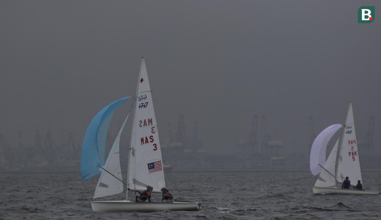 Pelayar asal Malaysia dan Pakistan mengatur arah saat mengikuti Asian Sailing Championship di Laut Jakarta, Senin (25/6/2018). Turnamen ini merupakan uji kesiapan jelang Asian Games XVIII. (Bola.com/Vitalis Yogi Trisna)